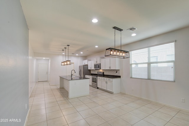 kitchen featuring light tile patterned floors, visible vents, appliances with stainless steel finishes, tasteful backsplash, and dark countertops