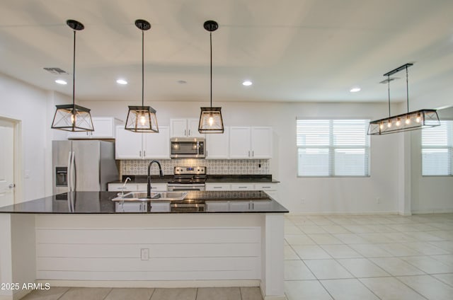 kitchen with dark countertops, tasteful backsplash, stainless steel appliances, and a sink