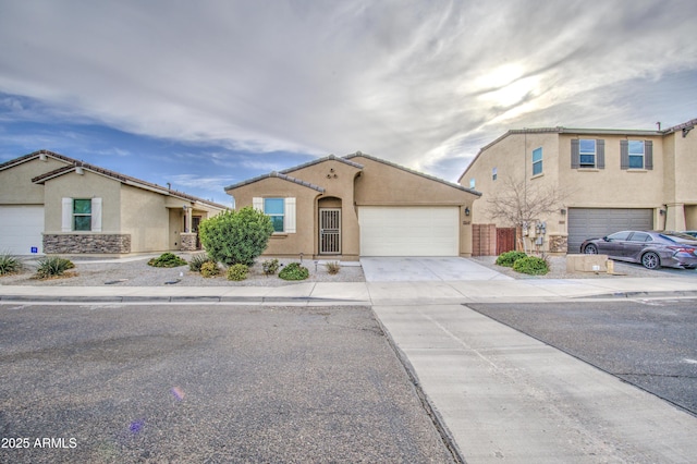 view of front of home with concrete driveway, an attached garage, fence, and stucco siding