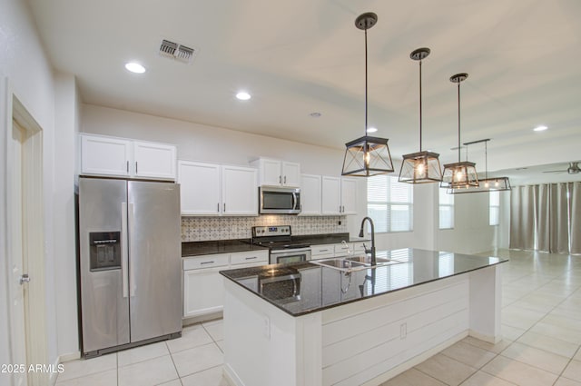 kitchen with a sink, visible vents, white cabinets, appliances with stainless steel finishes, and tasteful backsplash