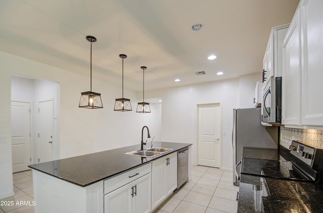 kitchen with backsplash, white cabinetry, stainless steel appliances, and a sink