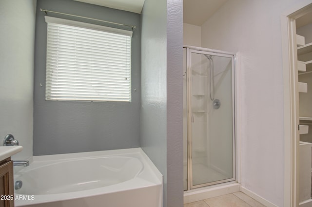 bathroom with a garden tub, a shower stall, vanity, and tile patterned floors