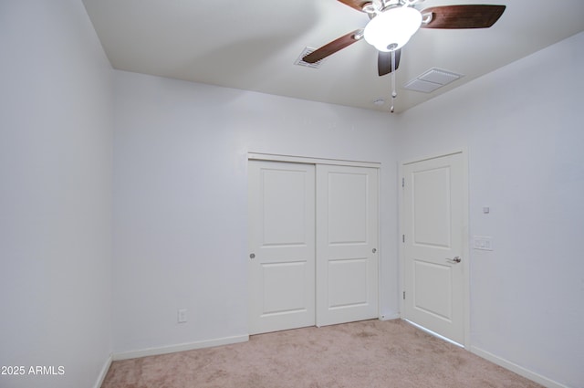 unfurnished bedroom with light carpet, a ceiling fan, visible vents, baseboards, and a closet