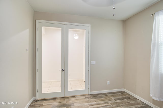 entryway featuring french doors, baseboards, and light wood finished floors