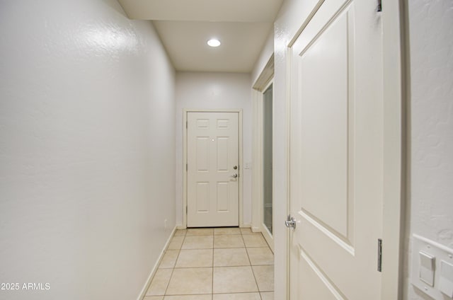 corridor featuring recessed lighting, light tile patterned flooring, and baseboards