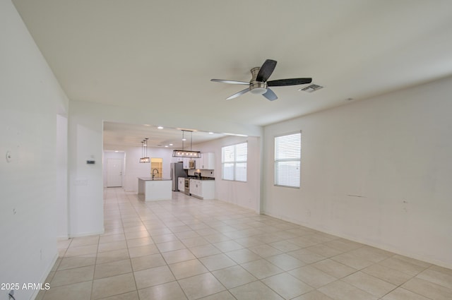 empty room with ceiling fan, light tile patterned floors, and visible vents