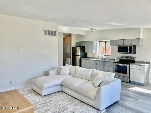 living room with lofted ceiling and light wood-type flooring