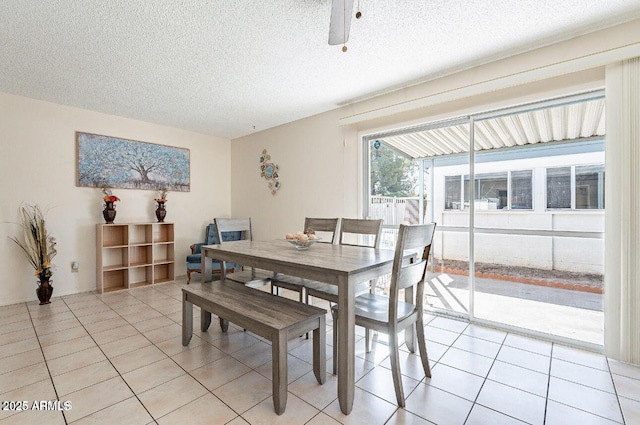 dining area featuring a textured ceiling and light tile patterned flooring