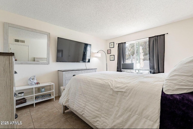 tiled bedroom featuring a textured ceiling