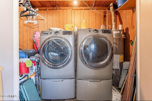 laundry area with wooden walls and washing machine and clothes dryer