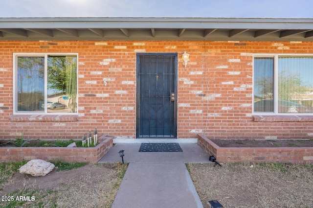 doorway to property featuring brick siding