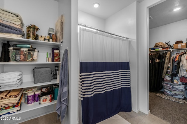 bathroom featuring recessed lighting, curtained shower, and a walk in closet