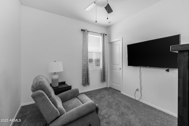 living area featuring baseboards, ceiling fan, and dark carpet