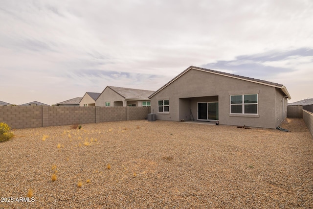 rear view of property featuring stucco siding and a fenced backyard