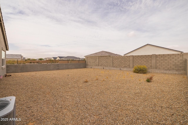 view of yard with central AC unit and a fenced backyard