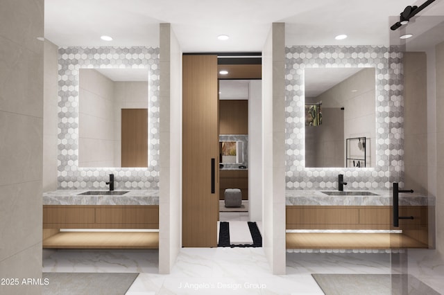 full bathroom with marble finish floor, tile walls, two vanities, and a sink