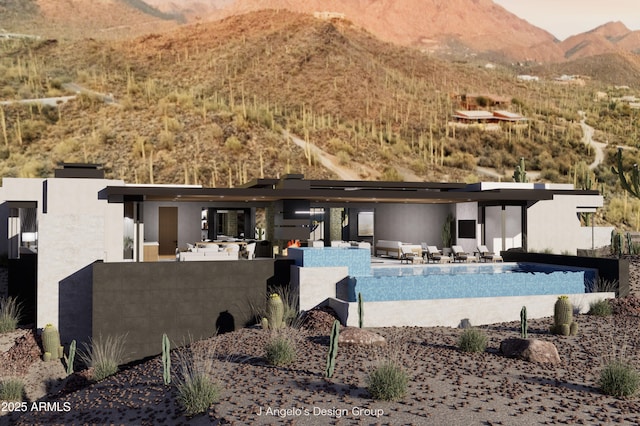 rear view of house with stucco siding, a mountain view, an outdoor pool, and a patio