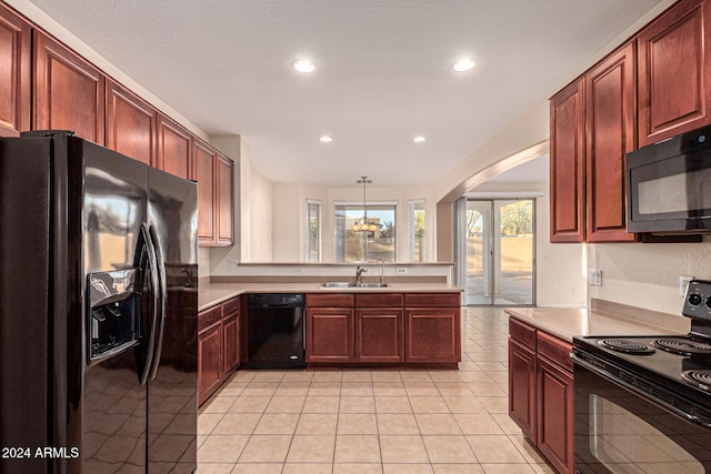 kitchen featuring sink, hanging light fixtures, kitchen peninsula, light tile patterned flooring, and black appliances