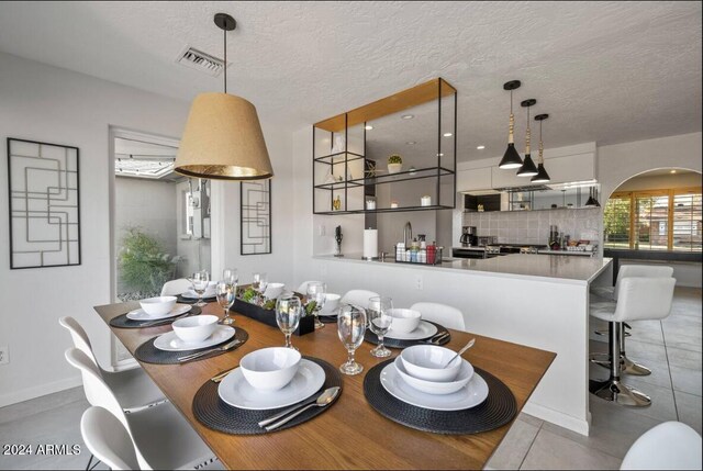 dining area featuring a textured ceiling and visible vents