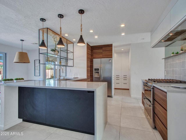 kitchen featuring stainless steel appliances, a sink, tasteful backsplash, modern cabinets, and custom range hood