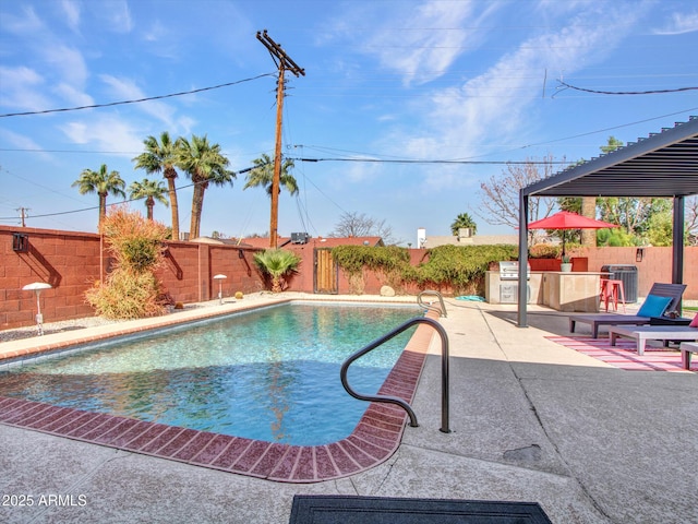 view of pool with a fenced in pool, a patio area, a fenced backyard, and an outdoor kitchen