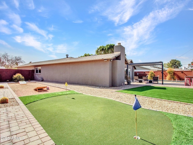 rear view of property with a patio, a chimney, fence, a pergola, and stucco siding
