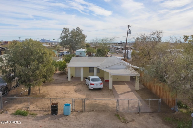 view of front facade with driveway, a fenced front yard, and a gate