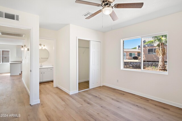 unfurnished bedroom with ceiling fan, light wood-type flooring, and a closet