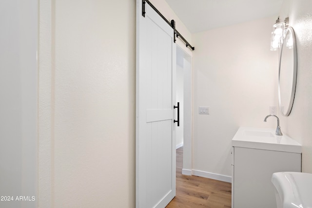 bathroom with toilet, vanity, and hardwood / wood-style flooring