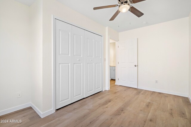 unfurnished bedroom with ceiling fan, a closet, and light hardwood / wood-style floors