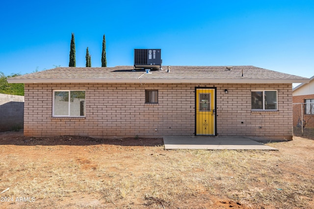 rear view of house with central air condition unit and a patio