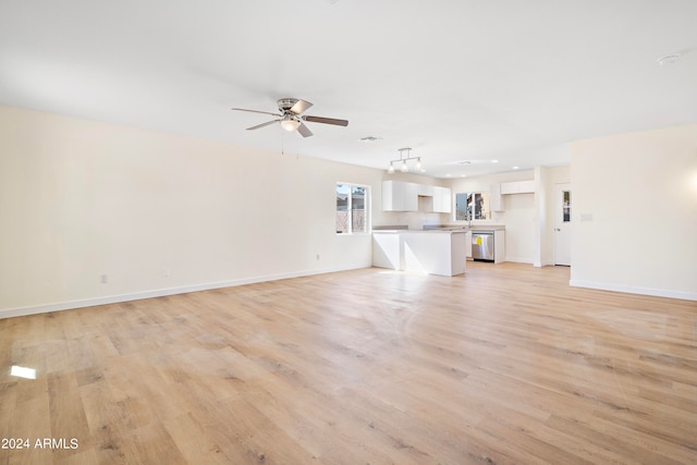 unfurnished living room featuring ceiling fan and light wood-type flooring