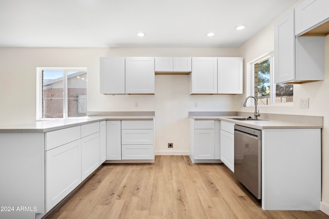 kitchen with white cabinets, light hardwood / wood-style floors, dishwasher, and sink