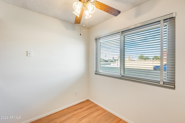 unfurnished room featuring ceiling fan, light hardwood / wood-style floors, and a textured ceiling