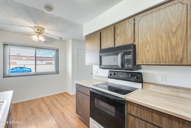 kitchen featuring white range with electric stovetop, ceiling fan, a textured ceiling, and light wood-type flooring