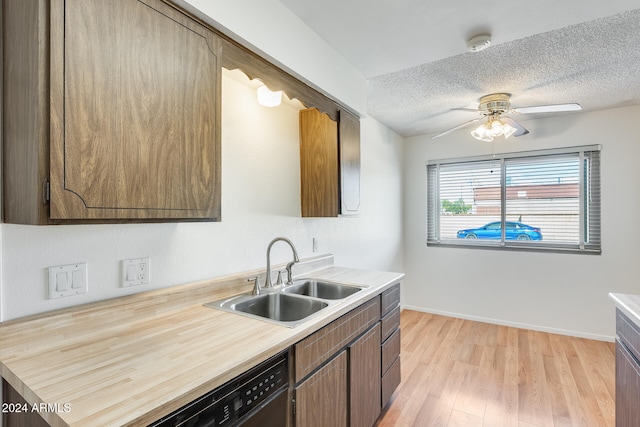 kitchen with sink, light hardwood / wood-style flooring, ceiling fan, a textured ceiling, and black dishwasher