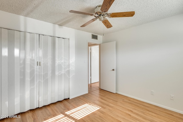 unfurnished bedroom with ceiling fan, light hardwood / wood-style floors, and a textured ceiling