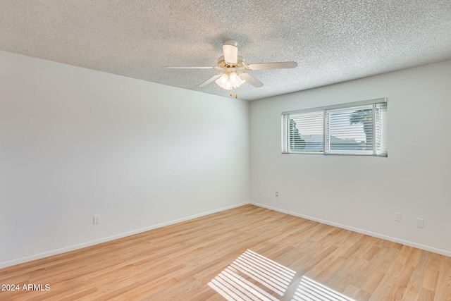 unfurnished room featuring a textured ceiling, light hardwood / wood-style flooring, and ceiling fan