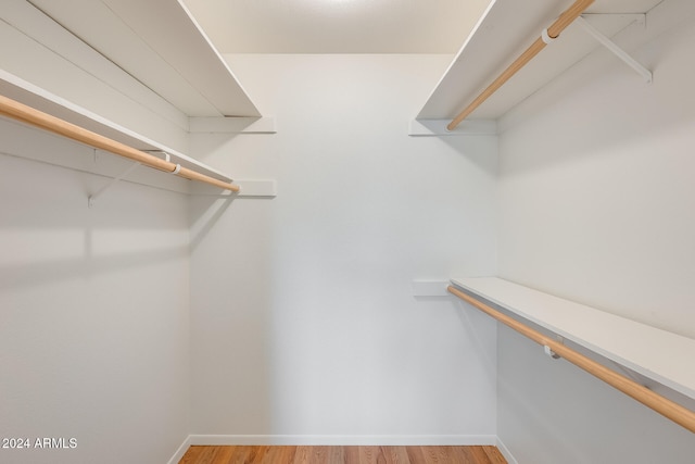 walk in closet with hardwood / wood-style floors