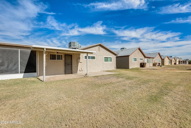 back of property with a patio area, a yard, and cooling unit