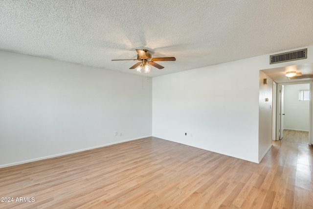 spare room featuring a textured ceiling, light hardwood / wood-style flooring, and ceiling fan