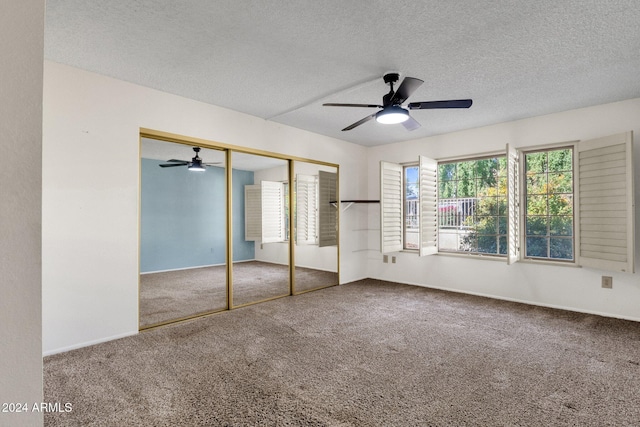 unfurnished bedroom featuring carpet, ceiling fan, a textured ceiling, and a closet