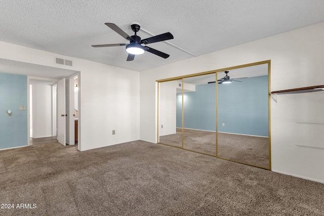 unfurnished bedroom featuring carpet, ceiling fan, a textured ceiling, and a closet