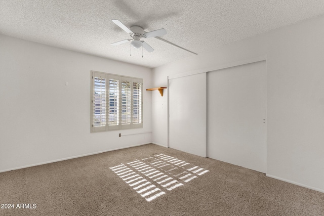 unfurnished bedroom with ceiling fan, a closet, carpet, and a textured ceiling