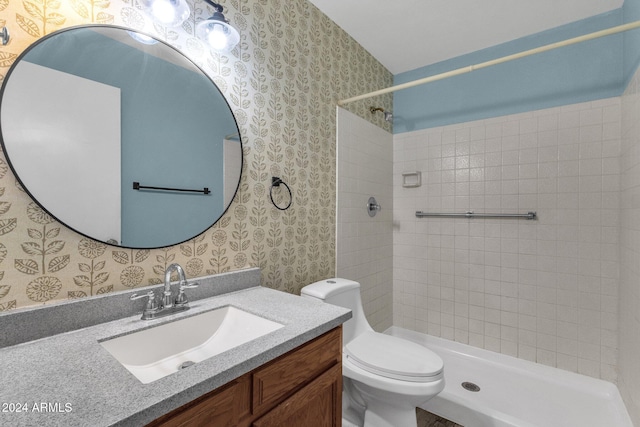 bathroom featuring vanity, toilet, and tiled shower