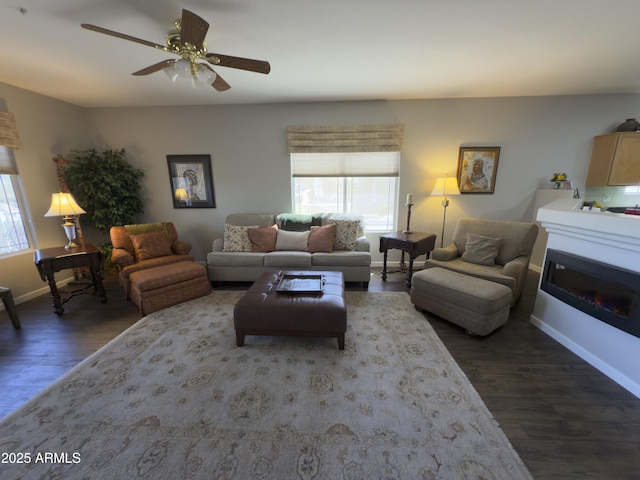 living room featuring a ceiling fan, baseboards, and wood finished floors