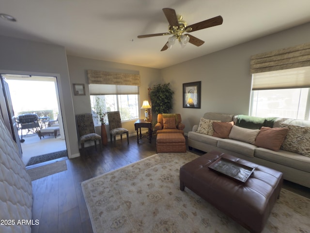 living room featuring baseboards, wood-type flooring, and ceiling fan