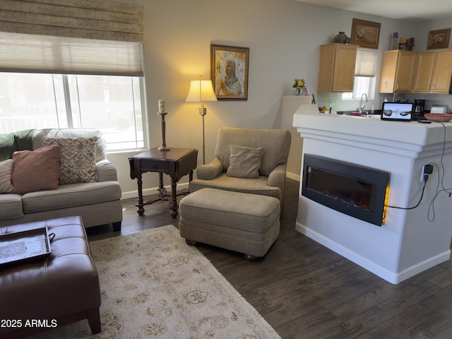 living room with dark wood finished floors, plenty of natural light, and baseboards