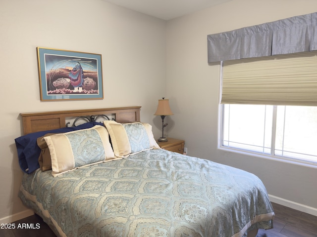 bedroom featuring baseboards and wood finished floors