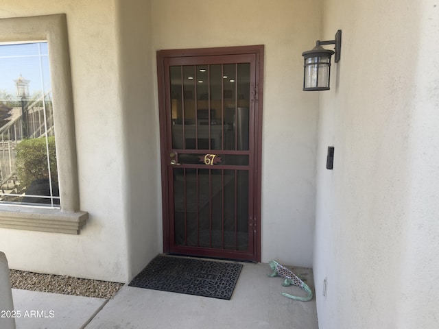 doorway to property featuring stucco siding